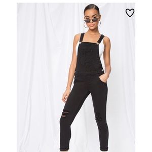 Brand new black overalls with tags and wrapping.